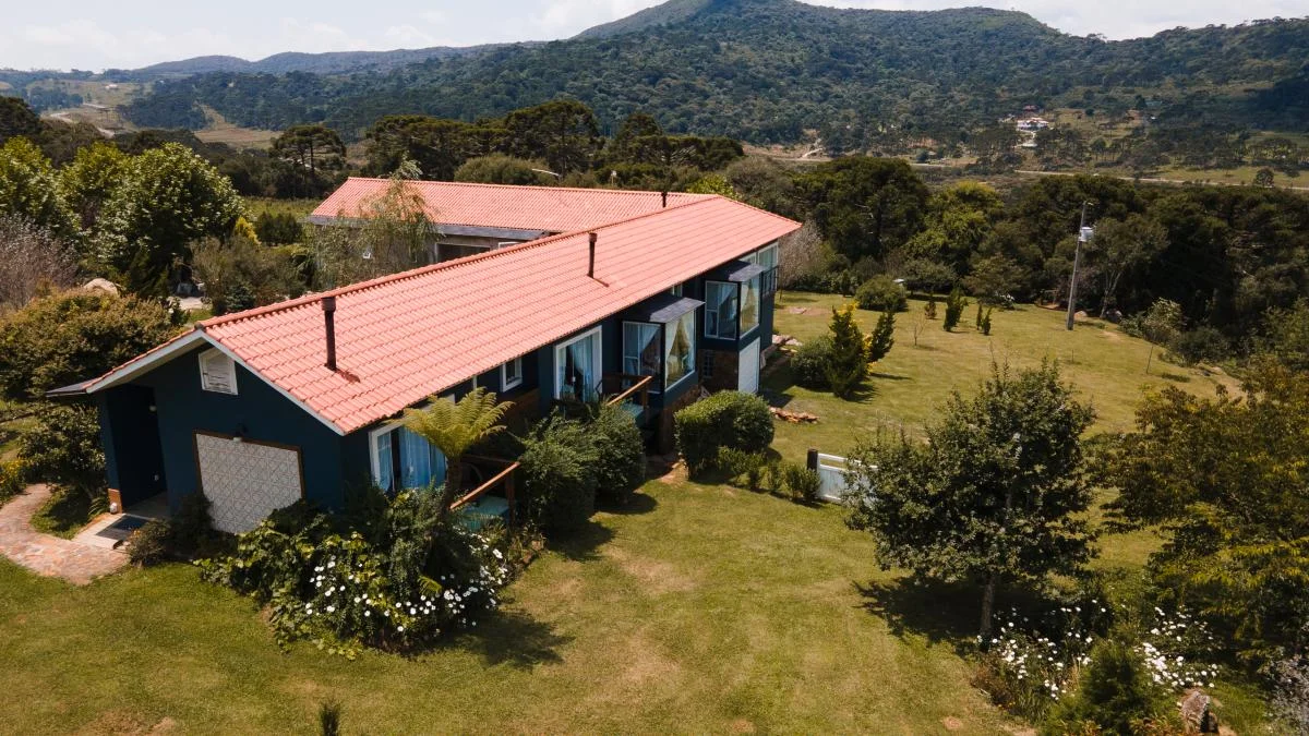 Vista aérea da Pousada Cantos e Encantos entre montanhas.
