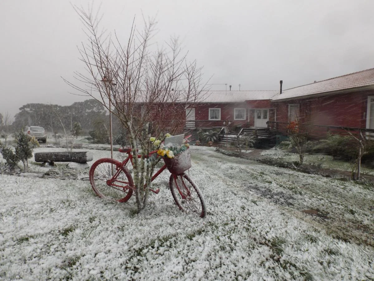 Jardim da Pousada Cantos e Encantos coberto de neve.