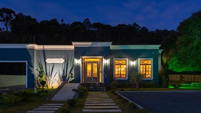 Entrada de um restaurante recomendado pela Pousada Cantos e Encantos à noite, recepção acolhedora.