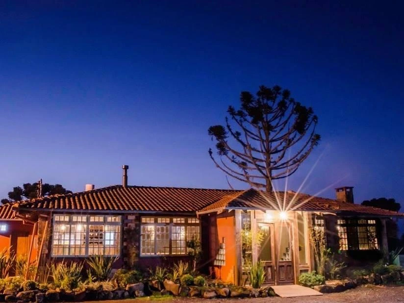 Restaurante iluminado à noite em meio à natureza.