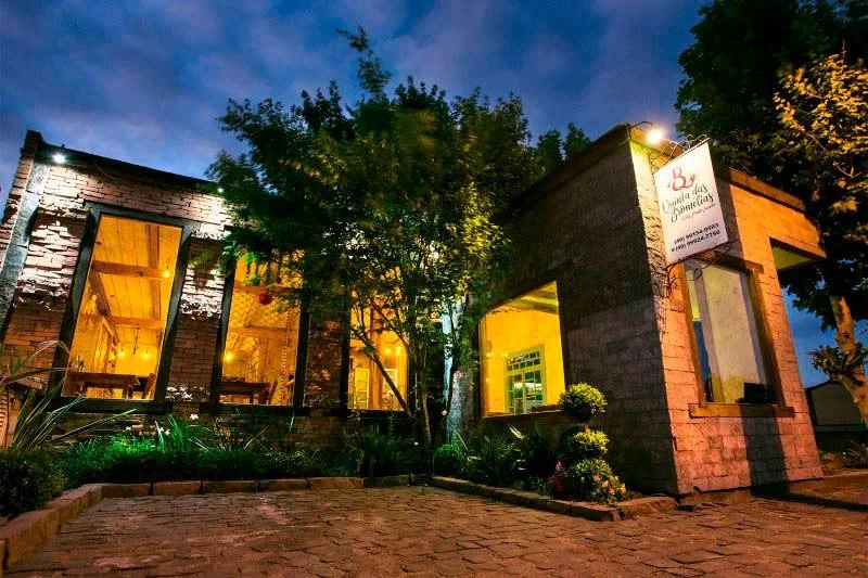 Fachada noturna de um restaurante recomendado pela Pousada Cantos e Encantos em Urubici, clima intimista e romântico.