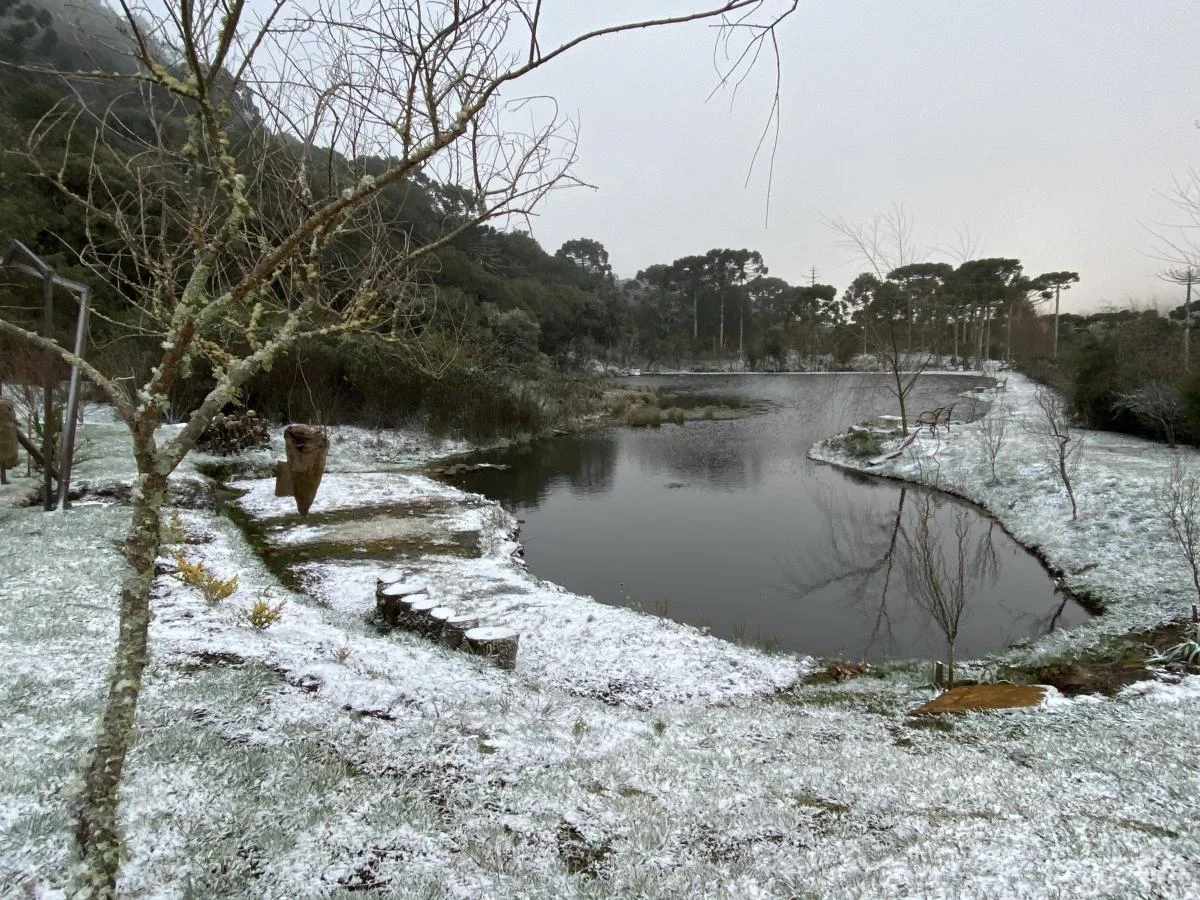 Jardim da Pousada Cantos e Encantos coberto de geada no inverno.