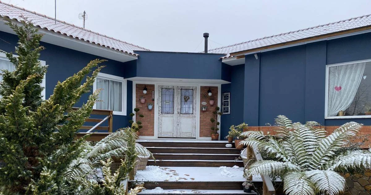 Fachada da Pousada Cantos e Encantos em meio à neve em Urubici
