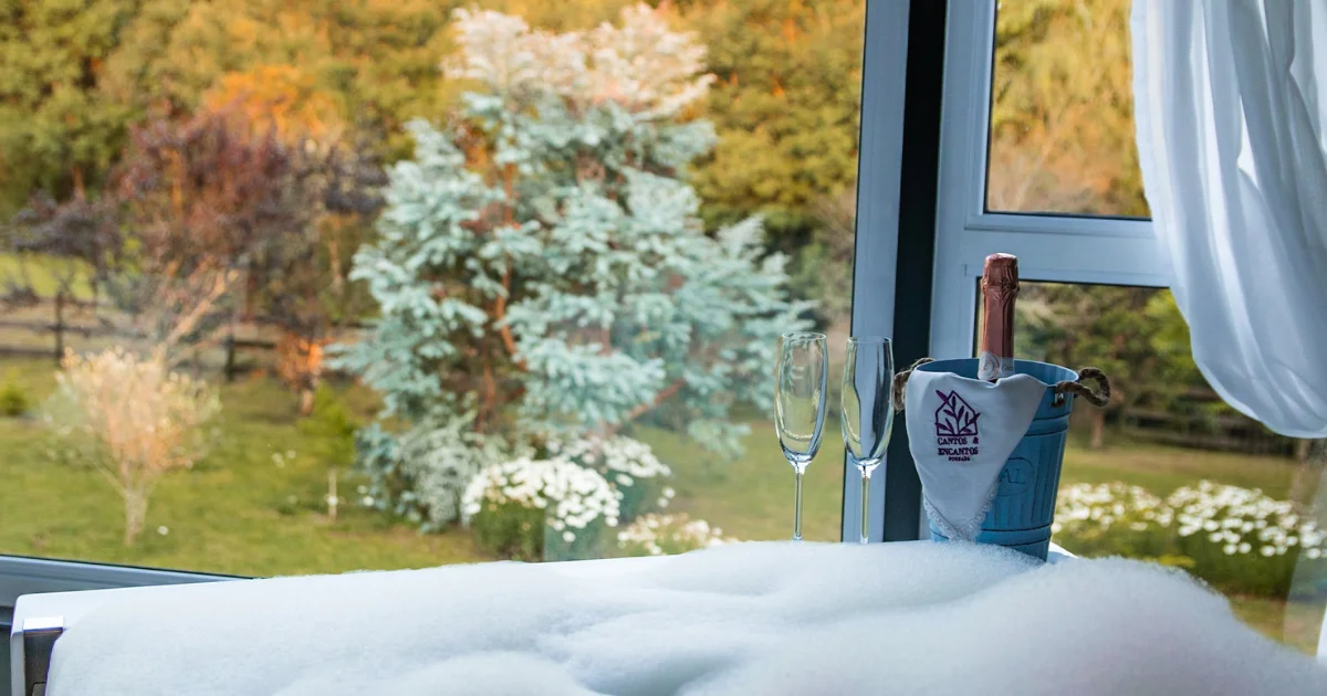 Espumante, banheiro e vista do jardim da Pousada Cantos e Encantos.