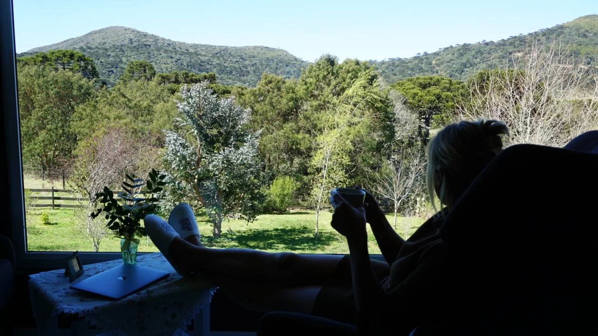 Hóspede relaxando com vista externa da Pousada Cantos e Encantos.
