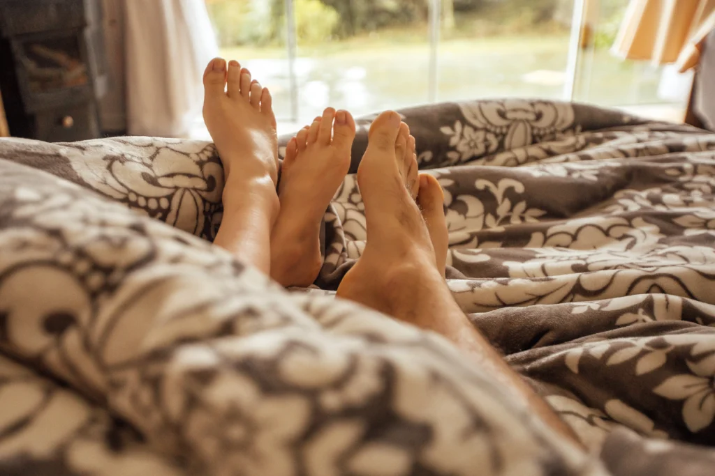 Casal relaxando em suíte com vista para a serra.