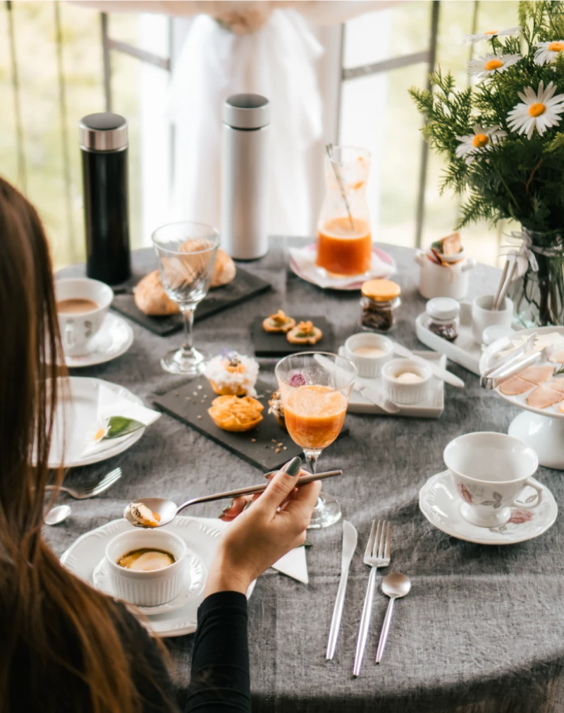 Mesa de café da manhã servida com cuidado na Pousada Cantos e Encantos em Urubici, com itens artesanais e clima acolhedor