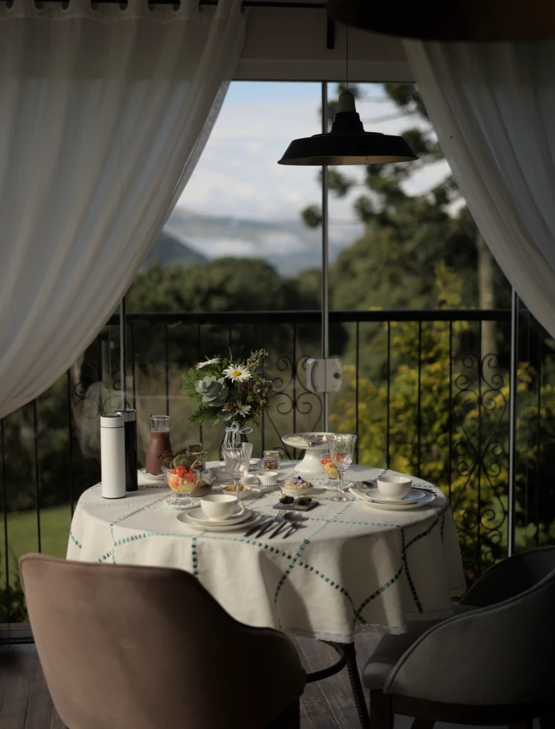 Mesa posta ao ar livre na Pousada Cantos e Encantos em Urubici, com vista para a natureza e atmosfera intimista