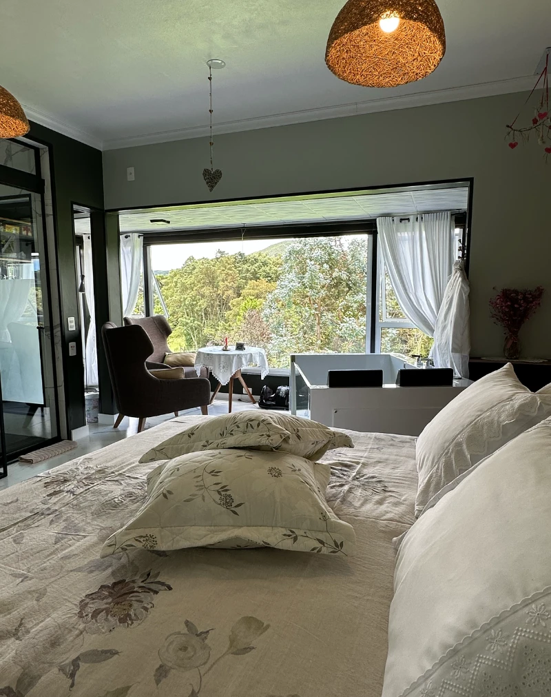 Suíte Premium Jasmim da Pousada Cantos e Encantos em Urubici, com design contemporâneo, grandes janelas e vista para a natureza