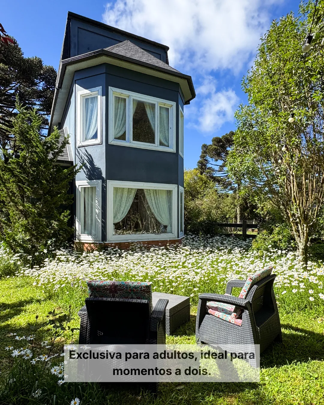 Vista do sobrado da Pousada Cantos e Encantos em Urubici cercado por flores silvestres