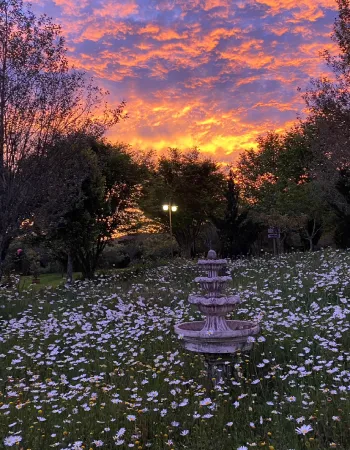 Pôr do sol no jardim da Pousada Cantos e Encantos com fonte e paisagem natural