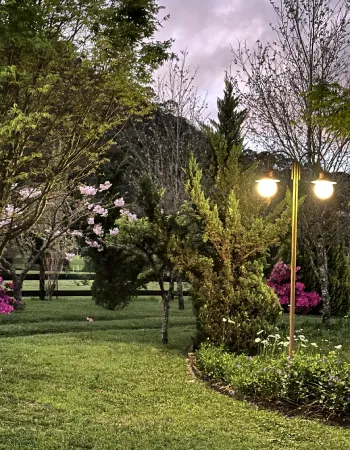 Jardim iluminado ao entardecer na Pousada Cantos e Encantos em Urubici