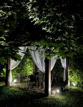 Espaço de descanso iluminado à noite no jardim da Pousada Cantos e Encantos em Urubici