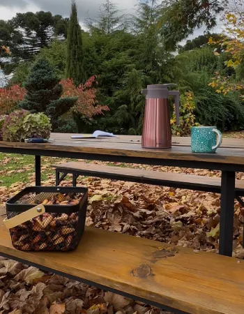 Mesa externa no jardim da Pousada Cantos e Encantos em Urubici durante o outono