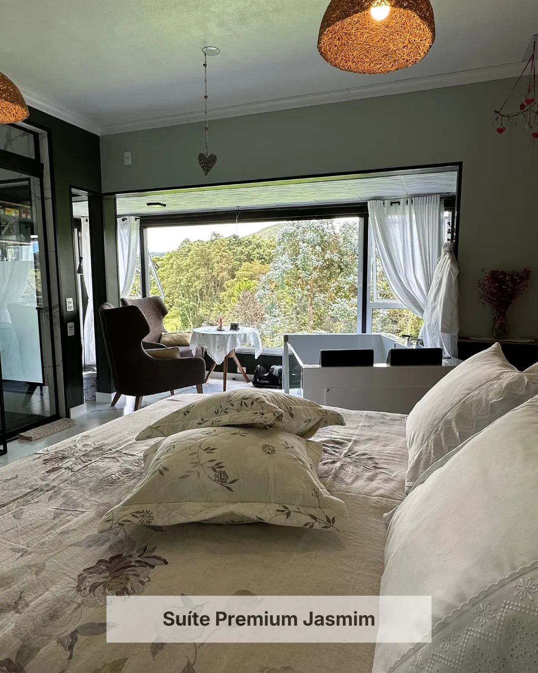 Suíte da Pousada Cantos e Encantos em Urubici com cama confortável e vista para a natureza