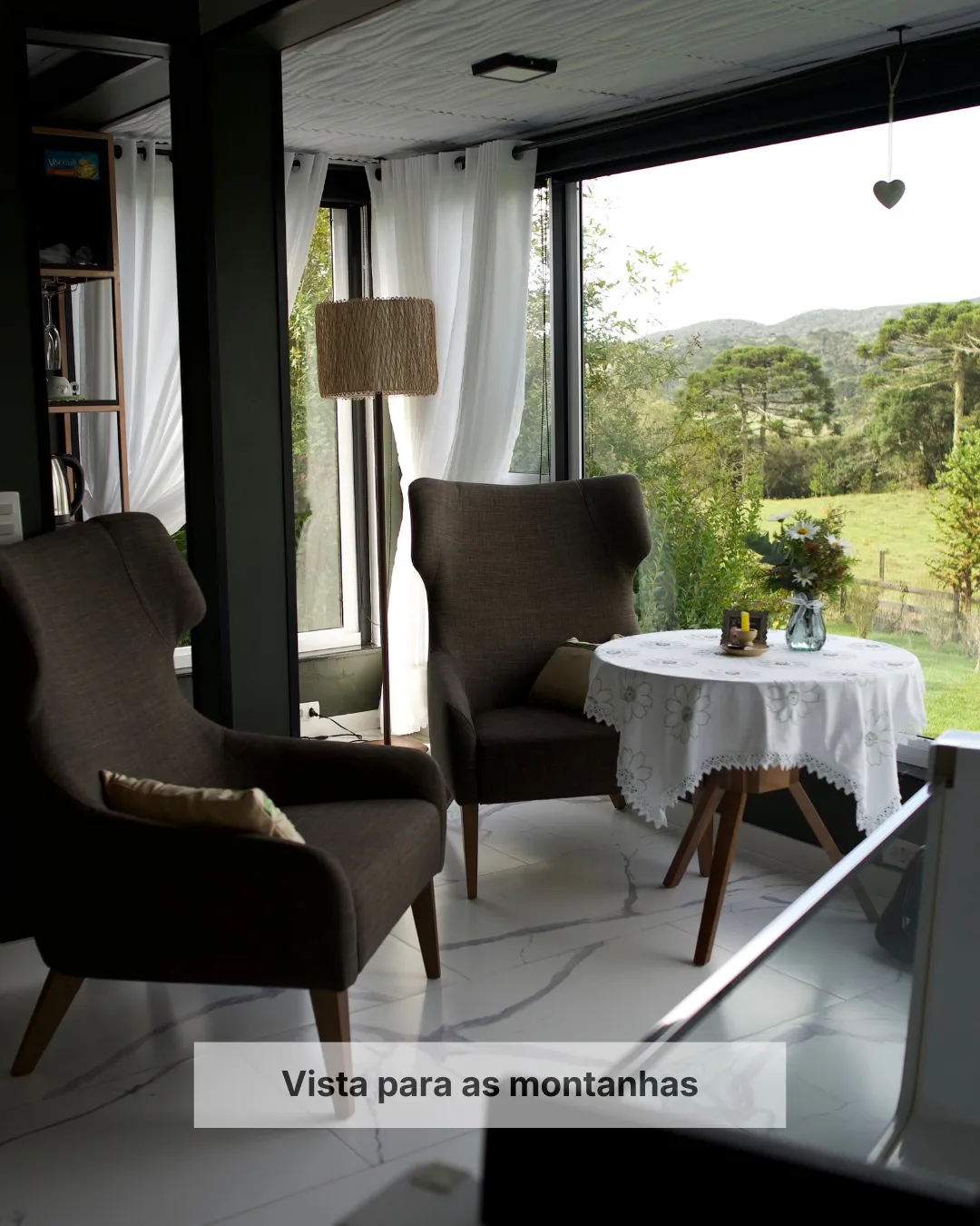 Sala de estar da Pousada Cantos e Encantos em Urubici com vista para as montanhas