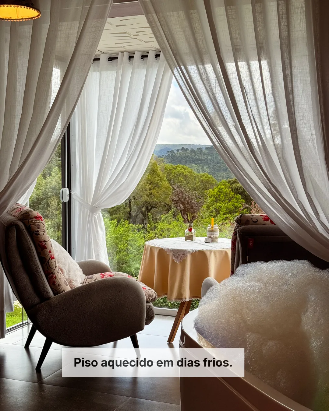 Área de estar da suíte da Pousada Cantos e Encantos em Urubici com vista para as montanhas